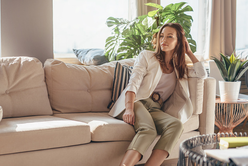 Retrato de una mujer de negocios en casa sentada en el sofá photo