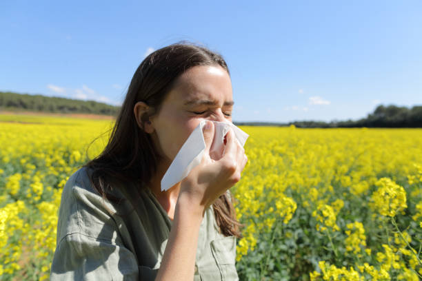 istock Allergic woman blowing nose in a field in spring 1317261097