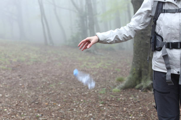 Uncivil trekker throwing garbage to the ground in nature