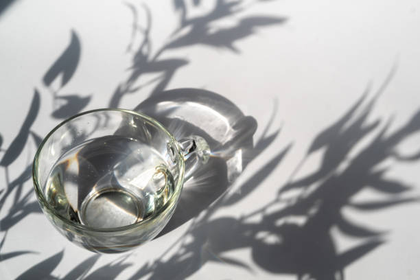 istock Abstract shadow pattern on white background and glass cup with water. Texture for the background 1317263546