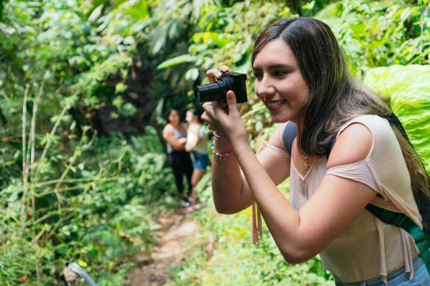 istock Latin Woman Using Camera In Tropical Forest 1317263775