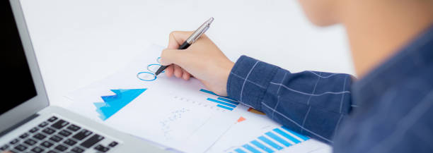 istock Young asian business man pointing document data graph and chart with pen, marketing and investment, report of statistics profit for financial, economic and growth of finance, management and planning. 1317265190