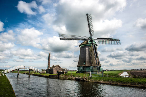 windmill and river bridge, the netherlands - zaanse schans bridge house water imagens e fotografias de stock