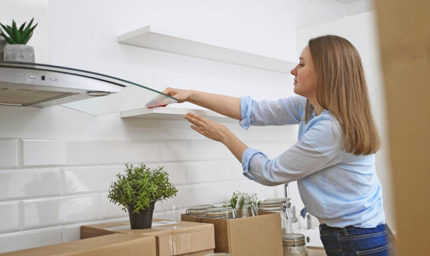 Woman wipes the kitchen after moving to new apartment. stock photo