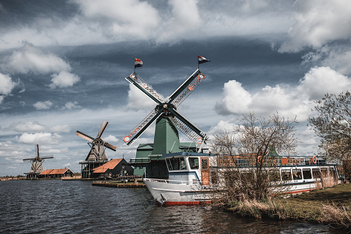 27th of April, 2013. A number of windmills and yacht moored on river bank in the Netherlands.