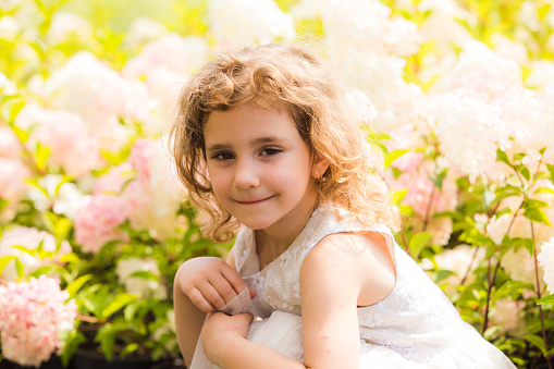 The girl runs into the field with her arms outstretched like an airplane. Carefree childhood, summer freedom, travel. International Children Day. Mosquito repellent, cottage core.