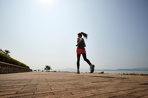 young asian adult woman running jogging outdoors