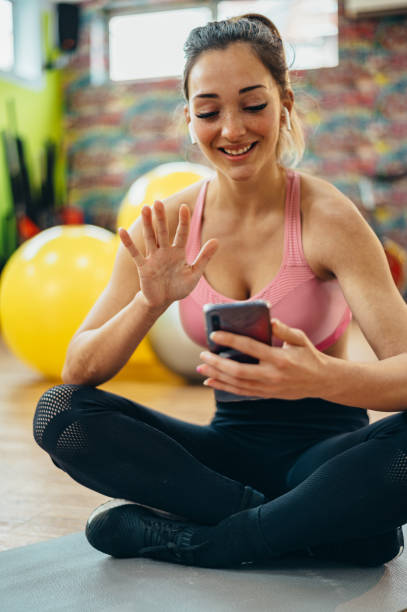 istock Woman using a smartphone for a video call while training in the gym 1317275083