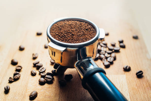 Portafilter with grounded coffee and coffee beans close-up
