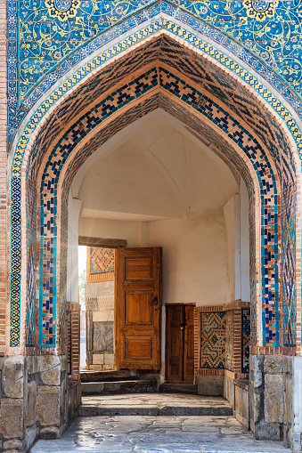 Ornate Doorway into the Tilya-Kori Madrasah or Tilla-Kori Madressa. Islamic ornate opulent mosaic tile Iwan with small Entrance Hall. Medieval Islamic Architecture Detail. Tilya-Kori Madrasah was built between 1646–1660. It is an islamic  residential college for students, but also played the role of a  Grand Mosque. Tilya-Kori Madrasah, Samarkand, Registan, Uzbekistan, Central Asia.