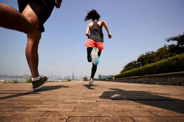 Photo of young asian people running in seaside public park