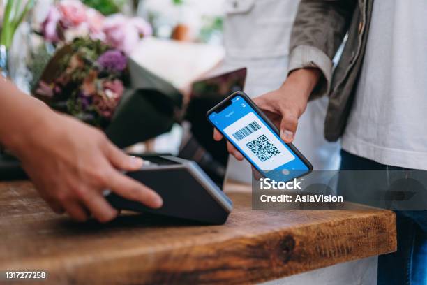 Happy Couple Shopping At The Flower Shop Close Up Of Young Asian Man Paying For A Bouquet By Scanning Qr Code Scan And Pay A Bill On A Card Machine Making A Quick And Easy Contactless Payment Nfc Technology Tap And Go Concept Stock Photo - Download Image Now