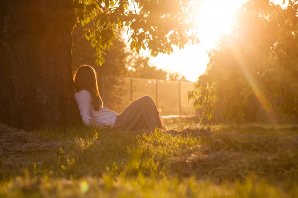 istock Woman Sitting By Tree On Glass 1317277514