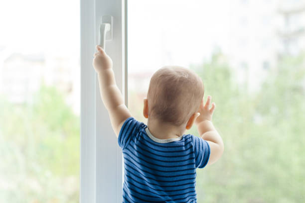 istock Rear View Of Boy Standing By Window 1317277529