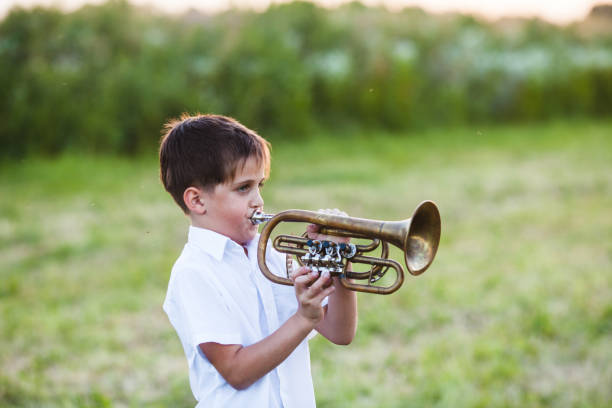 istock Smiling Boy Playing Trumpet Outdoors 1317277539