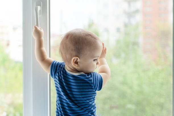 istock Rear View Of Boy Standing By Window At Home 1317278577