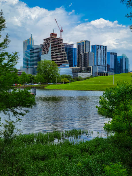 istock Green space in downtown Austin Texas with Pond and huge Skyscraper under construction 1317279074