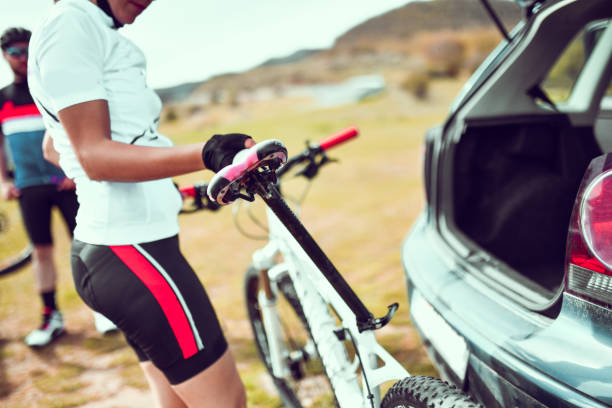 istock Female Cyclist Setting Up Bicycle While Unpacking Parts From Car Trunk During Mountain Biking 1317280515