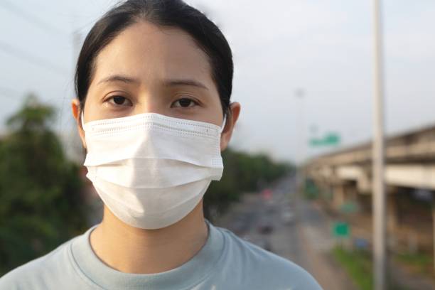 istock A woman wearing a surgical mask is standing on a flyover. 1317282203