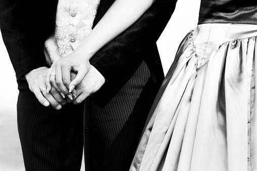 Male and female hand with a wedding ring. Black and white wedding photography
