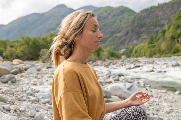 istock Young woman meditating in nature 1317282621