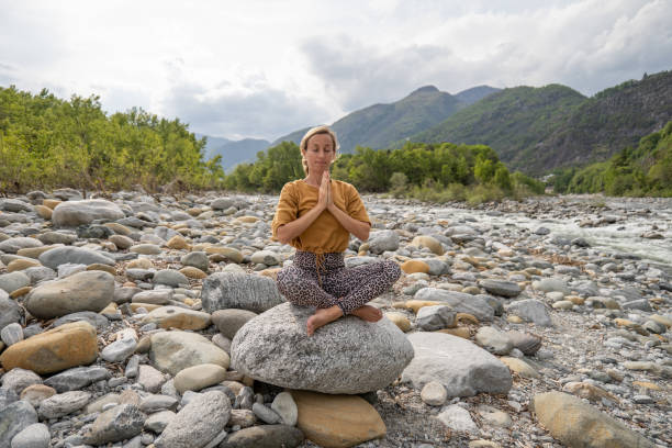 istock Young woman meditating in nature 1317283590
