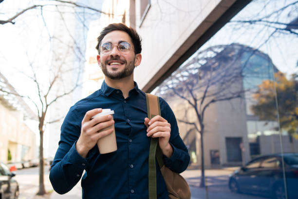 istock Young man holding a cup of coffee while walking outdoors. 1317283849