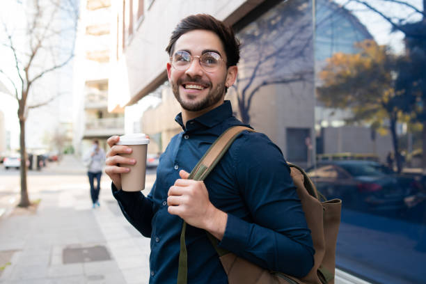 istock Young man holding a cup of coffee while walking outdoors. 1317283894