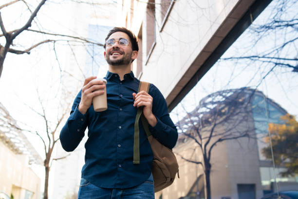 istock Young man holding a cup of coffee while walking outdoors. 1317283922