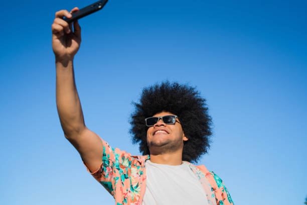 istock Latin man taking a selfie with phone outdoors. 1317284029