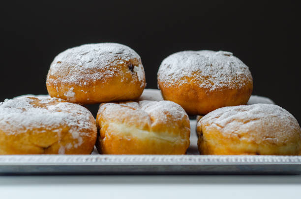 istock Berliner Pfannkuchen, a German donut, traditional yeast dough deep fried filled with chocolate cream and sprinkled with powdered sugar, 1317284067