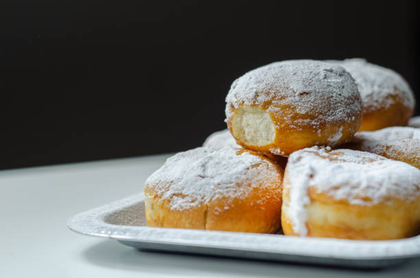 istock Berliner Pfannkuchen, a German donut, traditional yeast dough deep fried filled with chocolate cream and sprinkled with powdered sugar, 1317284115