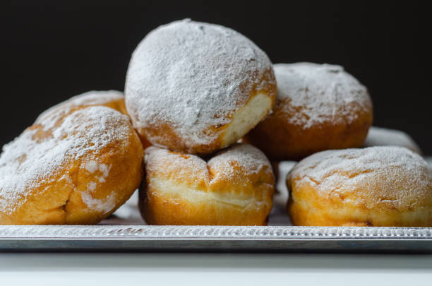 istock Berliner Pfannkuchen, a German donut, traditional yeast dough deep fried filled with chocolate cream and sprinkled with powdered sugar, 1317284116