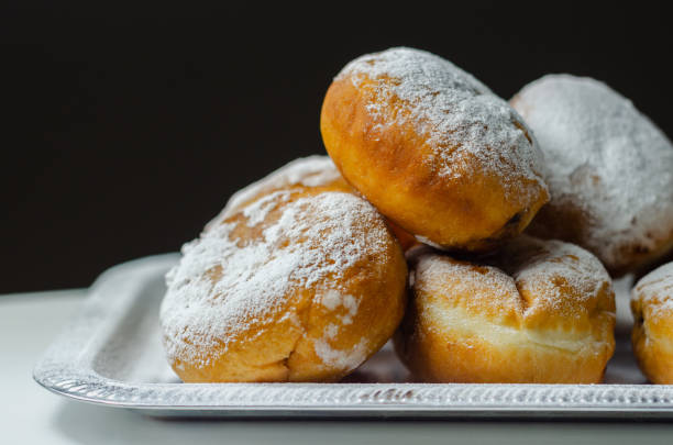 istock Berliner Pfannkuchen, a German donut, traditional yeast dough deep fried filled with chocolate cream and sprinkled with powdered sugar, 1317284232