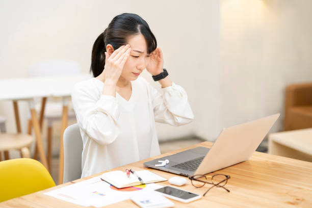 職場で頭痛に苦しむ女性 - めまい 女性 日本人 ストックフォトと画像