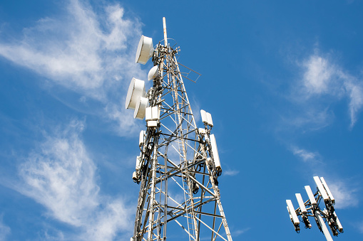 Radio, communication and cell towers on blue sky background