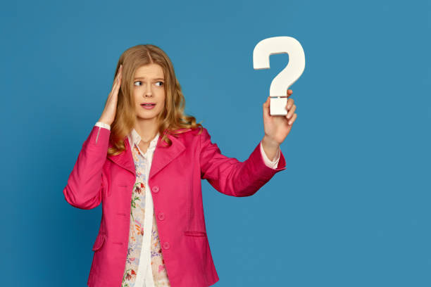 istock blonde woman in pink jacket holding question mark 1317291530