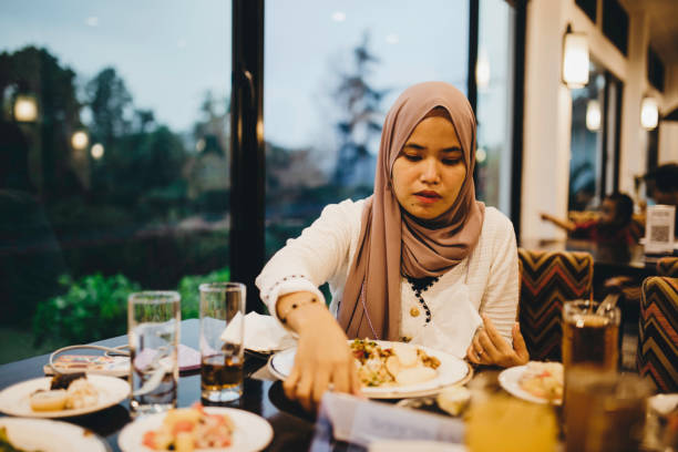 muslim woman eating in restaurant - gourmet enjoyment food freshness imagens e fotografias de stock