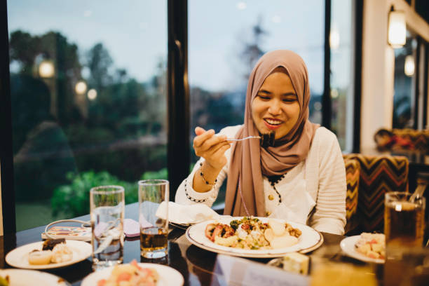 istock muslim woman eating in restaurant 1317292341