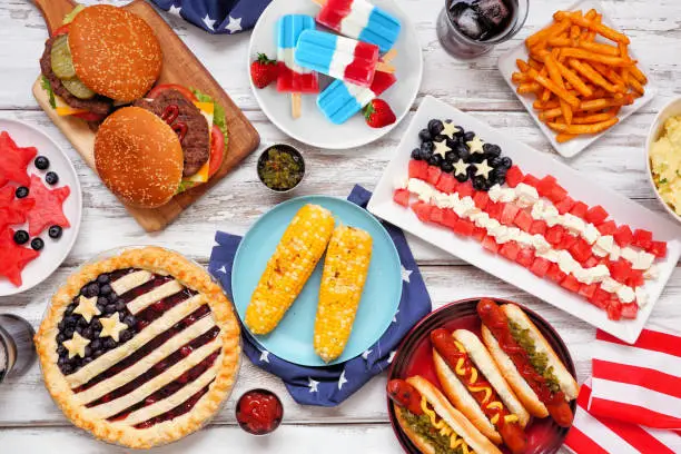 Fourth of July, patriotic, American themed food. Above view table scene on a white wood background.