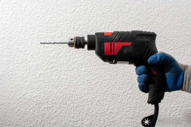 istock Person wearing gloves holding a drill with bit 1317296483