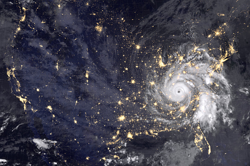 Huge hurricane over America, night photography. Lights of night cities and the eyes of the hurricane are clearly visible. Collage with abstract hurricane. Elements of this image furnished by NASA.\n\n/urls:\nhttps://visibleearth.nasa.gov/images/147028/hurricane-douglas-heads-toward-hawaii/147030l\nhttps://www.nasa.gov/press-release/nasa-invests-51-million-in-innovative-ideas-from-us-small-businesses\n(https://www.nasa.gov/sites/default/files/thumbnails/image/gsfc_20171208_archive_e001590_orig.jpg)\nhttps://images.nasa.gov/details-GSFC_20171208_Archive_e001437.html