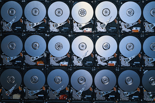 wallpaper of numbers of hard drives show inside metal disk and parts in pattern texture in cool blue tone light and shade