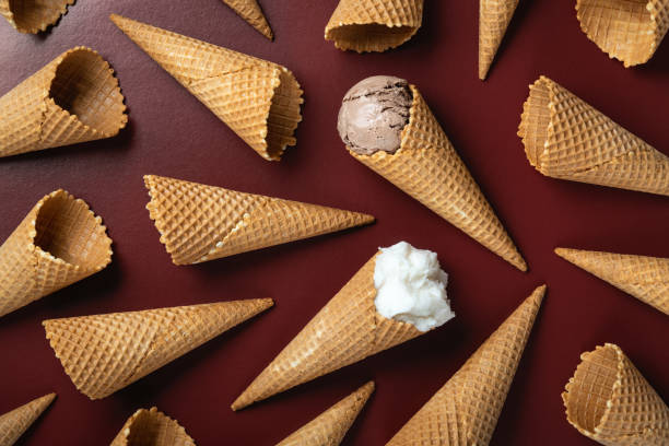 istock Ice cream and waffle empty ice cream cones on brown background, flat lay 1317300820
