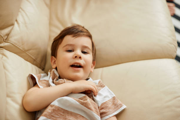 istock Cute little boy relaxing on the sofa and looking at camera. 1317303176