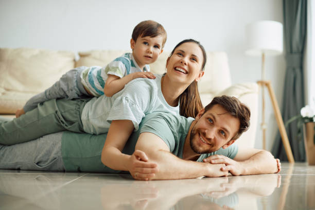 istock Happy family having fun while making human pyramid on the floor at home. 1317303265