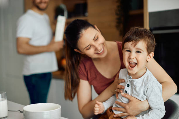 istock Carefree kid laughing while having breakfast with his parents at home. 1317303299