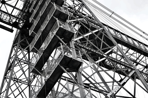 Black and white close-up image of a section of an old listed cantilever bridge constructed in 1902 crosses the River Usk in Newport and is a grade 1 listed structure with cantilevered sections, the main girder truss gives it an overall length of 232m