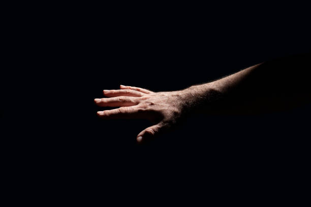 istock Light shining on a male hand in total darkness 1317307220