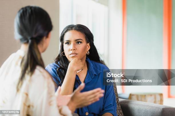 Unrecognizable Female Patient Gestures As Female Therapist Listens Attentively Stock Photo - Download Image Now
